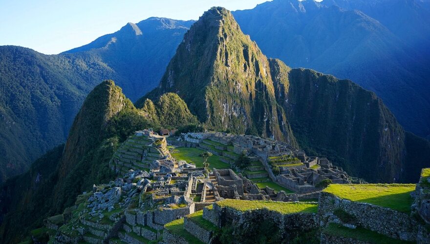Sunlight across the stone terraces of Machu Picchu with Huayna Picchu behind
