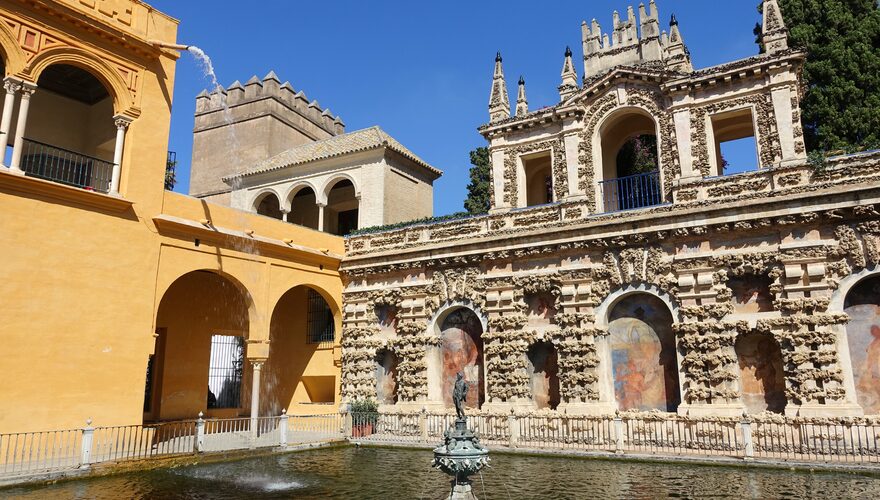 Ornate arches and reflecting pool in the gardens of the Alcázar of Seville, Spain